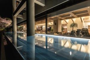 a swimming pool in a building at night at IZU RETREAT ATAWAGA SUIKO by Onko Chishin in Higashiizu