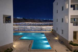 a pool in the middle of a building at night at Arian North Coast Chalet Santorini Resort El Alamein in El Alamein