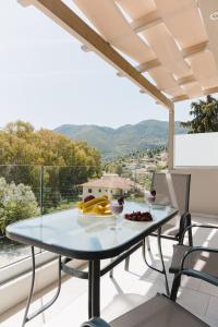 a table on a balcony with a view of the mountains at Ariti Luxury Apartment in Nikiana