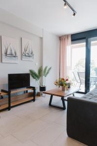 a living room with a television and a table at Ariti Luxury Apartment in Nikiana