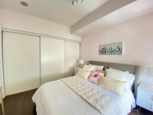 a bedroom with a white bed with white pillows at Luxurious Condo Apartment with Direct Subway Access in Toronto