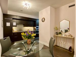 a dining room with a glass table and chairs at Luxurious Condo Apartment with Direct Subway Access in Toronto