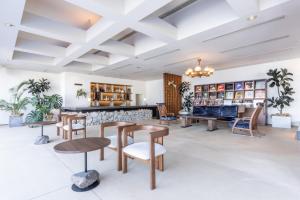a lobby with wooden tables and chairs at IZU RETREAT ATAWAGA SUIKO by Onko Chishin in Higashiizu