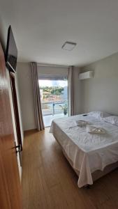 a bedroom with a bed and a large window at Pousada Serra da Ferrugem in Conceição do Mato Dentro +4 photos