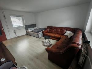 a living room with a leather couch and a bed at Lusana in Moravske-Toplice