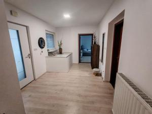 a hallway with white walls and wooden floors at Lusana in Moravske-Toplice
