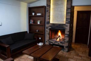 a living room with a fireplace with a couch and a table at Centro Vacacional Malintzi in Guadalupe