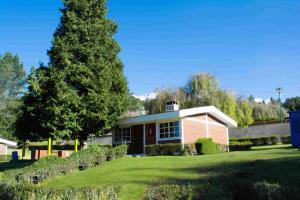 a red brick house with a tree in the yard at Centro Vacacional Malintzi in Guadalupe