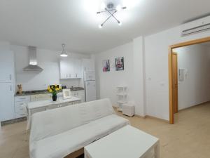 a white room with a bed and a kitchen at HOME CENTRO B max 5 personas HOME CENTRO A max 6 personas in Marchena
