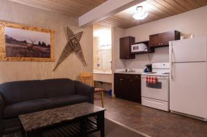 a living room with a couch and a white refrigerator at EasyStay Inn & Suites Fernie in Fernie