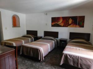 a group of four beds in a room at Casa Brusodia in Guadalajara +6 photos