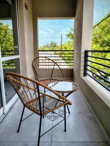 a rattan chair and a table on a balcony at El mejor depto de Villegas in General Villegas