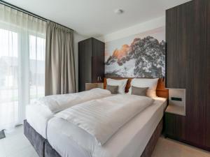 a bedroom with a large bed with white sheets at Grebenzen Lodge 55 in Sankt Lambrecht