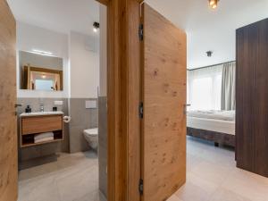 a bathroom with a toilet and a sink and a bed at Grebenzen Lodge 55 in Sankt Lambrecht +70 photos