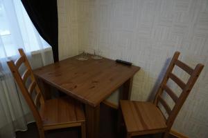 - une table en bois et 2 chaises avec des verres à vin dans l'établissement Yar Hotel, à Yaroslavl