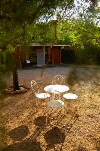 a white table and two chairs sitting next to a tree at Hostel Qiru Atacama in Sólor
