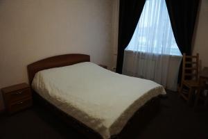 1 dormitorio con cama blanca y ventana en Yar Hotel, en Yaroslavl