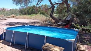 a large blue hot tub in the middle of a yard at Cabaña Nachitor in San Pedro de Atacama