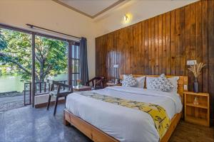 a bedroom with a large bed and a large window at By the Lake Boho Bhimtal in Bhīm Tāl