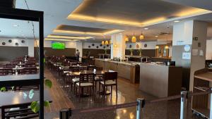 a restaurant with tables and chairs and a bar at Flat particular no Hotel Intercity Manaus in Manaus