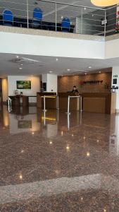 a person sitting at a desk in a lobby at Flat particular no Hotel Intercity Manaus in Manaus +19 photos