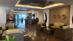 a lobby with couches and chairs and a bar at Flat particular no Hotel Intercity Manaus in Manaus