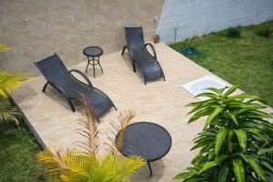 three black chairs and a table on a patio at Caesars Castle - Hidro e Vista Cinematográfica na Mantiqueira in Pindamonhangaba