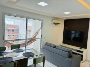 a living room with a couch and a tv at Play Ilhotas - Centro Teresina in Teresina
