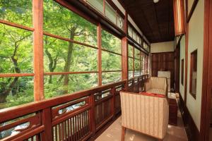 a screened in porch with two chairs and large windows at Fukuzumiro in Hakone +108 photos