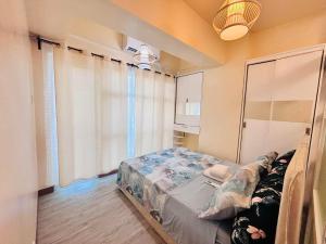 a bedroom with a bed and a large window at RR 21 Milan Residenze Fairview in Manila +18 photos