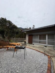 eine Terrasse mit zwei Picknicktischen vor einem Gebäude in der Unterkunft つちといろ in Otoyocho