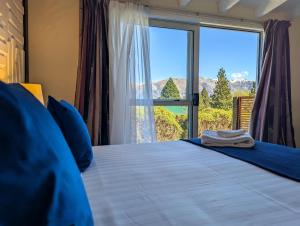 a bedroom with a bed with a large window at Mt Potts Lodge in Ashburton Lakes