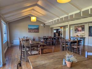 a dining room with wooden tables and chairs at Mt Potts Lodge in Ashburton Lakes