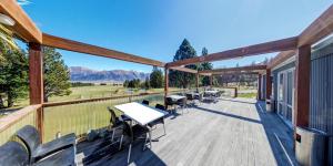 a deck with tables and chairs on a building at Mt Potts Lodge in Ashburton Lakes