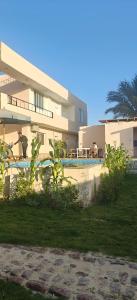 a building with a swimming pool in front of a house at Morsy Palace in Luxor