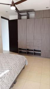 a bedroom with a bed and wooden cabinets at Practico Mini Departamento ideal para estancias largas in San Luis Potosí