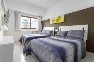 a bedroom with two beds with blue blankets at Caribe Carioca in Rio de Janeiro +30 photos