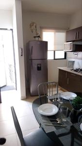 a kitchen with a table with chairs and a refrigerator at Practico Mini Departamento ideal para estancias largas in San Luis Potosí