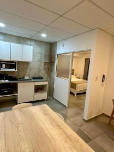 a room with a kitchen and a bedroom with a bed at Concepcion Apart in Concepción