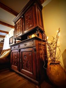 a large wooden cabinet in a room with a vase at Baboško in Rimavská Sobota