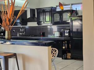 a kitchen with black cabinets and a black refrigerator at Villa Chelsy in Capesterre-Belle-Eau +1 photo