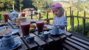 a little girl sitting at a picnic table with food at Keshiya Holiday Home in Nuwara Eliya +48 photos