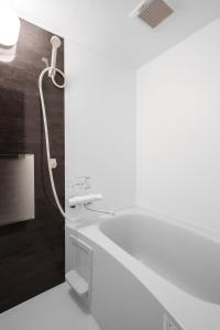 a bathroom with a shower and a white sink at Hills Niseko 106 in Niseko