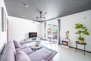 a living room with a couch and a tv at Hills Niseko 106 in Niseko +47 photos