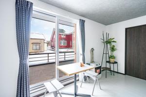 a room with a table and a large window at Hills Niseko 106 in Niseko