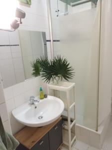 a bathroom with a white sink and a shower at Ku'damm Taler's Central - Self Check In in Berlin +10 photos
