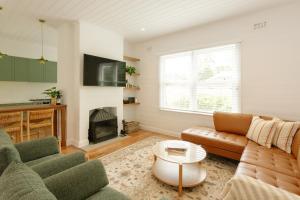 a living room with a couch and a fireplace at Greta Cottage, Berry in Berry
