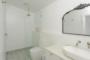a bathroom with a toilet and a sink and a mirror at Greta Cottage, Berry in Berry +15 photos