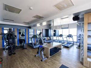 a gym with several treadmills and machines in a room at Stay Santos 2301 in Santos