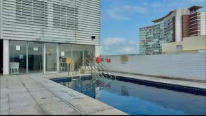 a building with a swimming pool in front of a building at Stay Santos 2301 in Santos